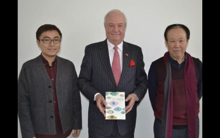 El embajador Jorge Heine (c); el hispanista Wen Ran (i), y el profesor universitario y traductor Zhao Zhenjian, posan hoy con el libro. EFE / R. Cañas