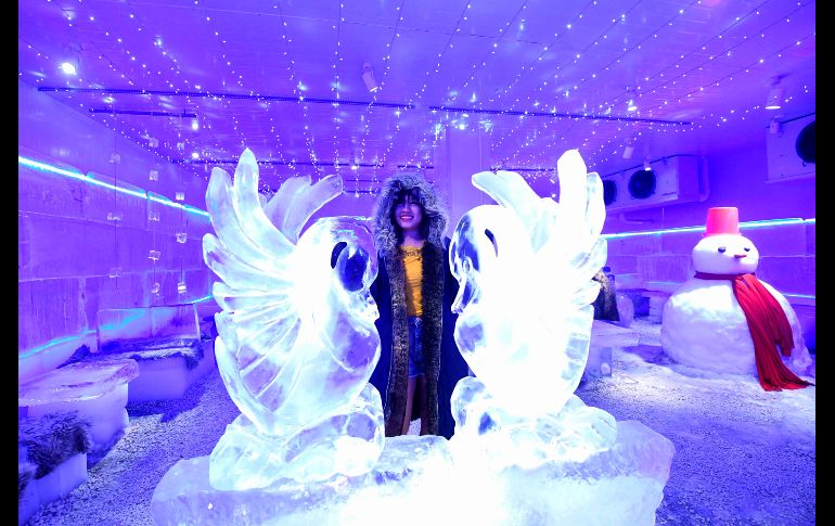 Una chica posa para una foto entre esculturas de hielo.