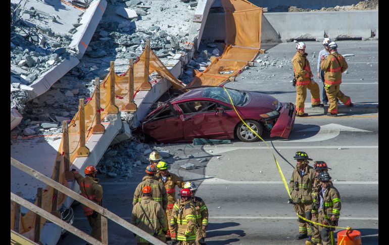 Miembros del departamento de bomberos trabajan en un puente peatonal que se derrumbó en las cercanías de la Universidad Internacional de Florida, en Miami, el 15 de marzo. Al menos cuatro personas murieron. EFE/G. Viera