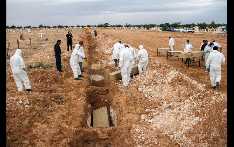 Policías y forenses entierran 112 cuerpos no identificados o no reclamados en un panteón municipal de Ciudad Juárez, Chihuahua, el 5 de octubre. AFP/H. Martínez
