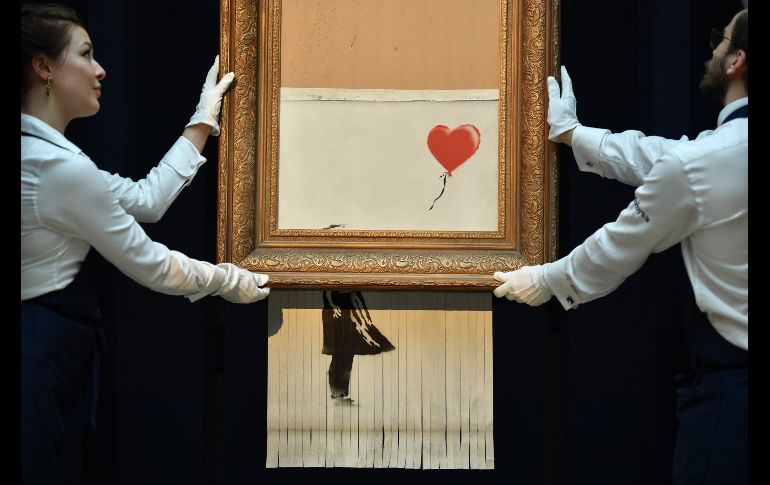 Trabajadores de Sotheby's muestran el 12 de octubre, en Londres, la obra del artista británico Banksy 