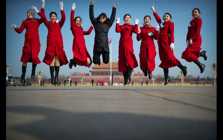 Edecanes saltan para una foto grupal, duante una reunión en la víspera del inicio de la sesión anual de la Asamblea Popular Nacional de China en Pekín. AP/M. Schiefelbein