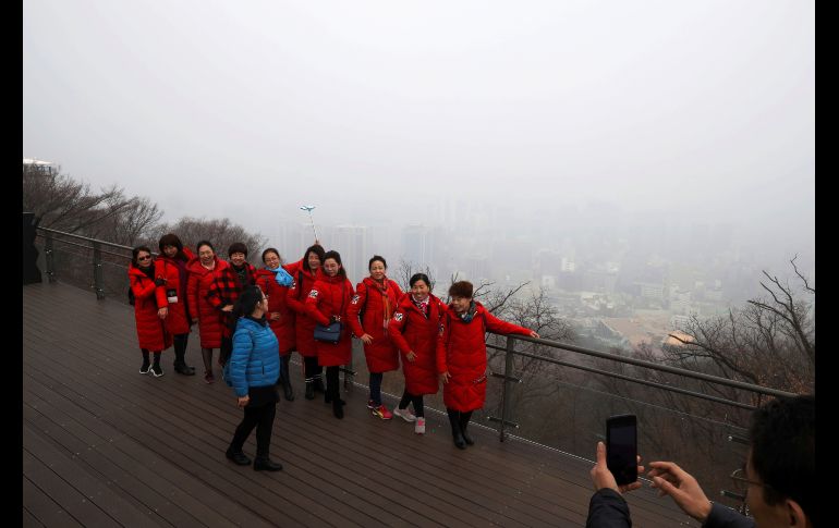 Turistas chinas posan para fotos con el centro de Seúl, Corea del Sur, como fondo, en un día contaminado. REUTERS/Kim H.