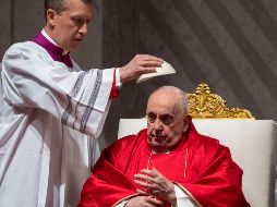 Monseñor Krzysztof Marcjanowicz coloca el casquete al Papa Francisco durante la liturgia de la pasión del Viernes Santo en la Basílica de San Pedro del Vaticano. AP