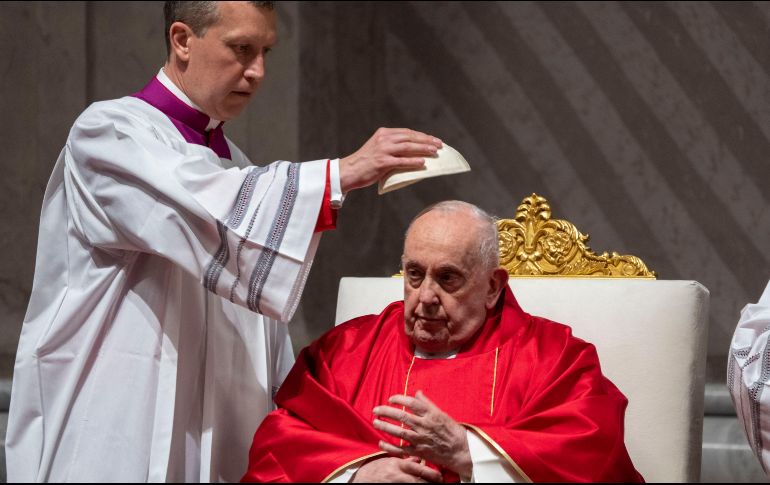 Monseñor Krzysztof Marcjanowicz coloca el casquete al Papa Francisco durante la liturgia de la pasión del Viernes Santo en la Basílica de San Pedro del Vaticano. AP
