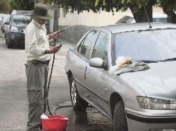 Pese a que las sanciones del SIAPA rebasan los 13 mil pesos por regar la calle o lavar los automóviles a chorros de manguera, hay ciudadanos que continúan haciéndolo. EL INFORMADOR