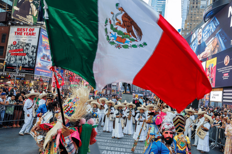 New York (United States), 02/05/2024.- People in costumes wave a Mexican flag and dance to the music of the Tlayacapan Brigido Santamaria band, one of the oldest bands in Mexico, while they play a concert at Times Square in New York, New York, USA, 02 May 2024. (Nueva York) EFE/EPA/SARAH YENESEL