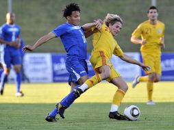 Julio César de León de Honduras y Ciprian Deac de Rumania, luchan por el balón durante partido amistoso. AP  /