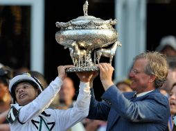 El jinete Mike Smith (izq) recibe el trofeo que lo acredita como el ganador en Belmont Stakes. AFP  /