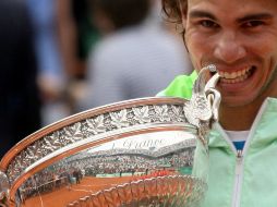 Rafael Nadal muerde el trofeo que lo acredita como el ganador del torneo Roland Garros. AP  /