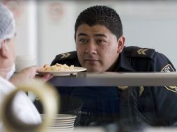 Un policía recibe sus alimentos este domingo en un destacamento de la Secretaria de Seguridad Pública en la Ciudad de México. EFE  /