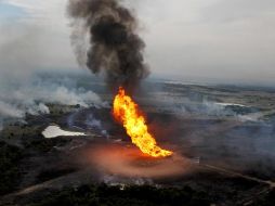 Llamas de decenas de metros de alto y una gigantesca columna de humo se perciben luego de la explosión de un gasoducto. AP  /