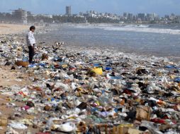 Un hombre se detiene entre restos de comida y plásticos en una playa de Juhu Chowpaty en Mumbai. EFE  /