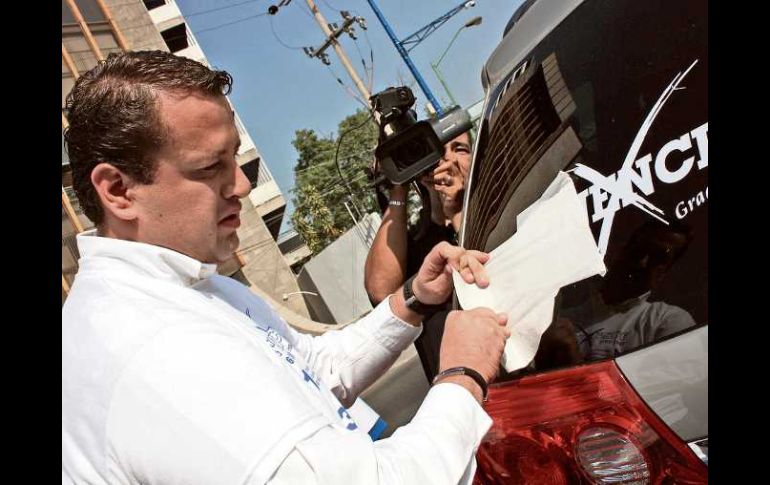 Hernán Cortés Berumen pegó calcomanías contra la tenencia en las inmediaciones de la Glorieta Minerva. A. HINOJOSA  /