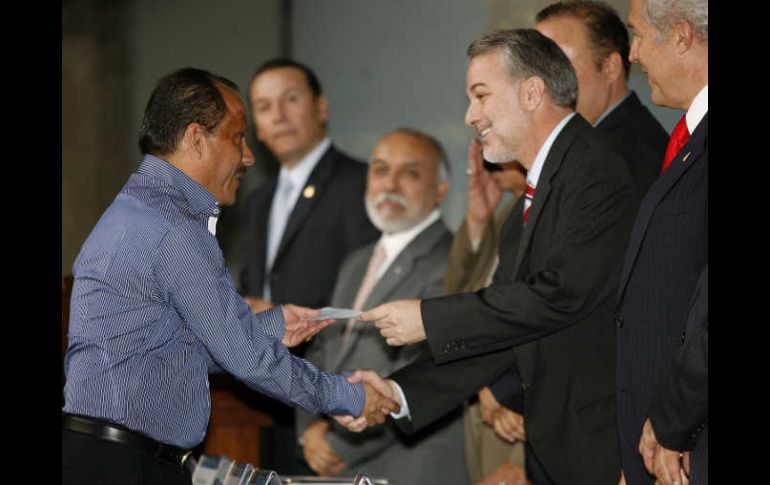 El gobernador del Estado (izq.), Emilio González Márquez, repartió ayer 145 millones de pesos entre 40 municipios de Jalisco.M. FREYRÍA  /
