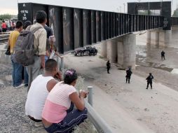 Algunos juarenses observan a los elementos de la Policía, mientras revisan la zona donde fue baleado Sergio Adrián Hernández. AFP  /