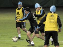 Maradona observa como Carlos Tevez disputa la pelota con un compañero. AFP  /