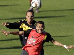 Dani Alves trata de ganar una pelota a su compañero Luis Fabiano. AP  /