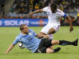 Diego Perez de Uruguay, lucha por el balón con Patrice Evra de Francia, durante el partido. EFE  /