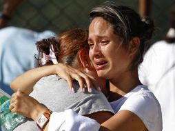 Carolina Torres y Diana Sepulveda, parientes de un trabajador fallecido en la explosión, esperan fuera del depósito de cadáveres. AP  /