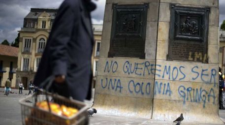 Un vendedor pasa frente a un monumento en Plaza Bolívar donde se lee el rechazo a las relaciones con Estados Unidos. AFP  /