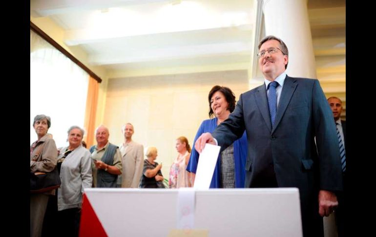 El candidato liberal Bronislaw Komorowski, deposita su voto junto a su esposa, Anna, en un colegio electoral de Varsovia. EFE  /