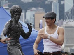 El actor junto a una estatua de Lee. AP  /