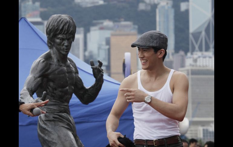 El actor junto a una estatua de Lee. AP  /