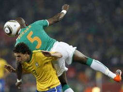 El jugador marfileño Didier Zokora (der) cae sobre el brasileño Elano (izq) en una acción del partido Brasil-Costa de Marfil. EFE  /