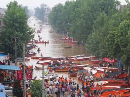 Recatistas chinos ayudan a transportar a la gente en lanchas debido al alto nivel del agua, en la provincia Jiangxi. AFP  /