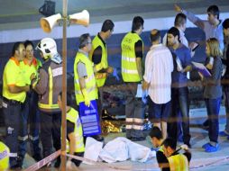 La policía judicial hace arreglos para mover los restos de las víctimas. AP  /