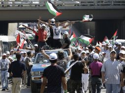 Palestinos ondean banderas en el trayecto para una manifestación de protesta por sus derechos civiles en Beirut. AP  /