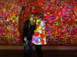 Dos mujeres posan para una fotografía frente a la obra ''Freak and Fluo'' de Roxana Olivieri y Loreto en ArteBA. EFE  /