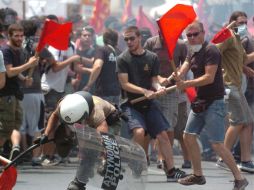 Manifestantes golpean a un policía durante una concentración de huelga en el centro de Atenas, hoy 29 de junio. EFE  /