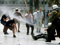 Manifestantes se enfrentan a agentes antimotines frente al Parlamento griego, en Atenas. EFE  /