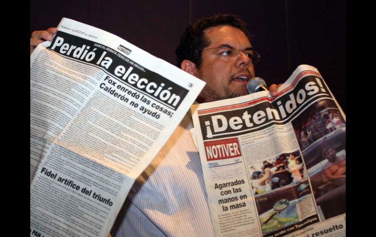 El secretario general del PAN en Veracruz muestra los periódicos que dan la victoria a Javier Duarte. EL UNIVERSAL  /