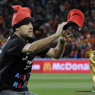 Un aficionado intenta poner un gorro a la Copa del Mundo