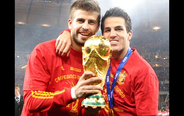 Los españoles Gerard Piqué y Cesc Fábregas cargan la Copa del Mundo. REUTERS  /