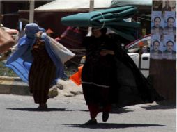 Mujeres cubiertas con burka pasean por la ciudad, sin saber que el llevar éste atuendo será un delito. EFE  /