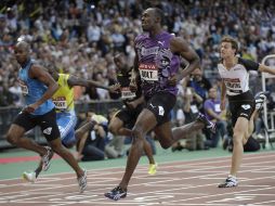 Usain Bolt tuvo que hacer un doble esfuerzo para rebasar a Powell y ganar la carrera con muy poco margen. EFE  /