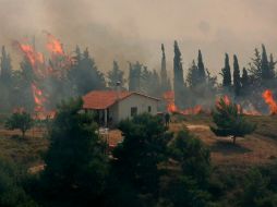 Una casa rodeada de llamas, en la localidad griega de Varnavas. EFE  /
