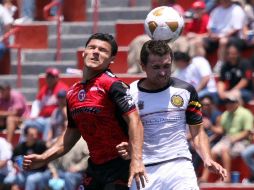 Javier Yacuzzi (izq.) de Tijuana disputa un balón con Carlos Balcázar de Leones Negros. MEXSPORT  /