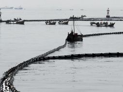 Embarcaciones limpian el derrame de la Bahía de Dalian. REUTERS  /