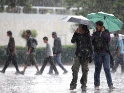 Dos capitalinas soportan la lluvia en el centro de la Ciudad de México. NTX  /