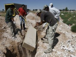 Trabajadores depositan este miércoles un ataúd en un cementerio de Ciudad Juárez, luego de que el cuerpo no fue reclamado. REUTERS  /