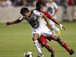 Javier Cortés, de los Pumas protege el balón de Wilman Conde. EFE  /
