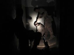 Infantes de Marina cuidan a un afgano detenido en un puesto de combate de las tropas de la OTAN. AFP  /