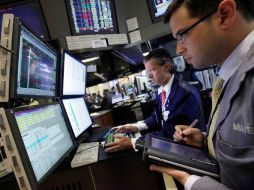 Donald Civitanova (I) y el comerciante Maier Tarlow trabajan en la Bolsa de Nueva York. AP  /