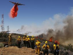 • Un avión y cientos de bomberos combaten las llamas que también afectaron torres de comunicación en Palmdale, California. AP  /