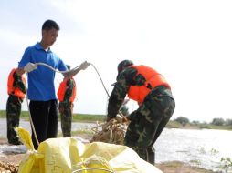 Soldados y trabajadores tratan de establecer seis puntos en el río Songhua para bloquear los recipientes de productos químicos. NTX  /